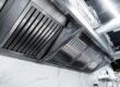 technician installing commercial kitchen exhaust hood – ProServe Mechanical