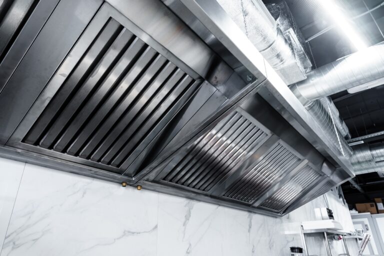 technician installing commercial kitchen exhaust hood – ProServe Mechanical