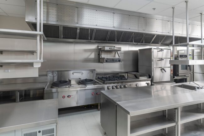 Technician opening kitchen exhaust access panel for maintenance – ProServe Hoods