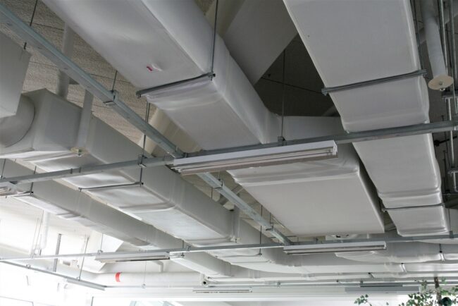 Commercial kitchen technician adjusting airflow for air balancing – ProServe Mechanical